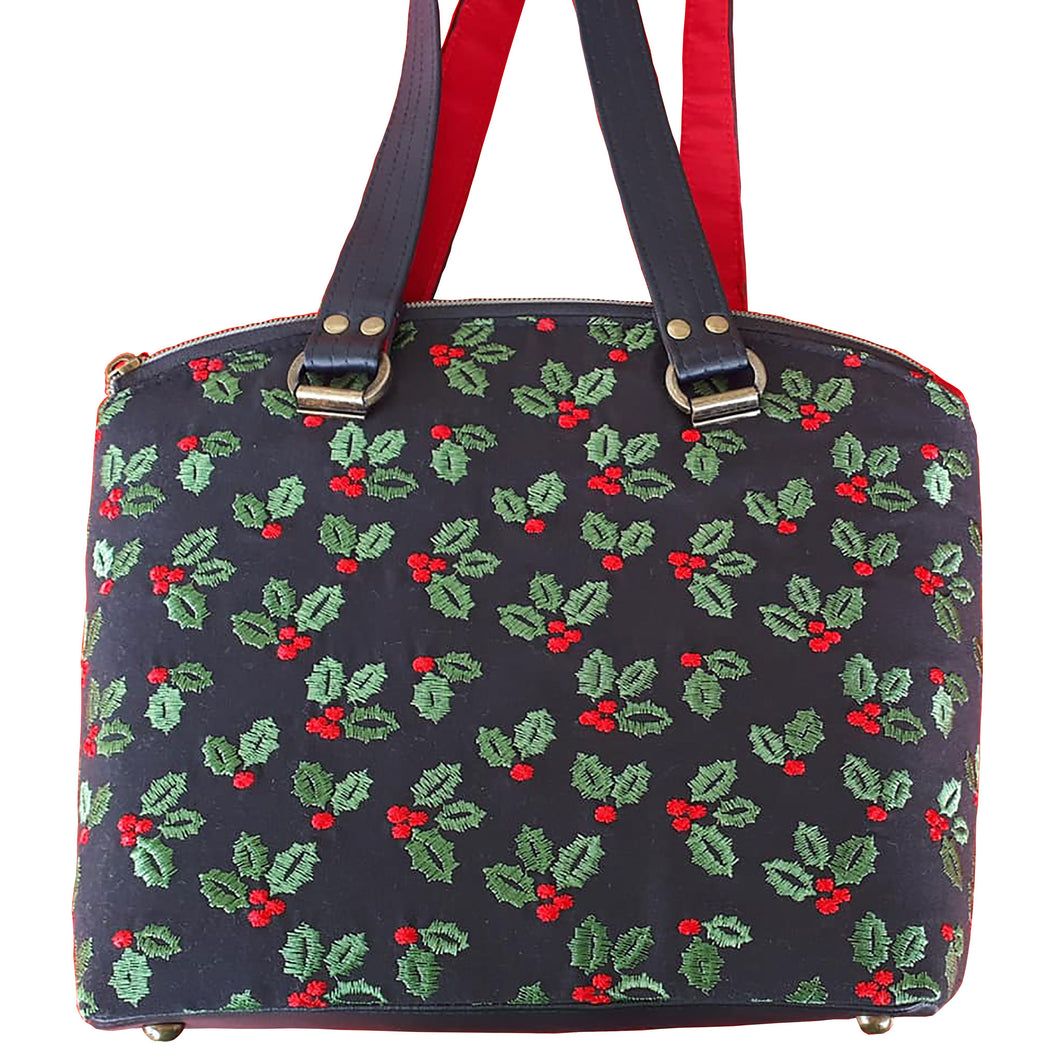 Domed handbag front, in black linen blend fabric with embroidered green holly leaves and red berries by just.a.tad accessories, sold by Gems from Paradise.