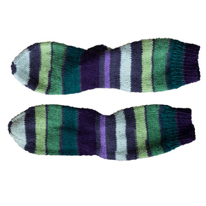 These handmade Socks by Sandy socks, laid flat, remind us of a grapevines with their variations of purple and green stripes and are sold by Gems from Paradise.